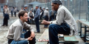 Tim Robbins and Morgan Freeman sitting outside on the benches playing checkers and talking in a scene from the film 'The Shawshank Redemption', 1994. (Photo by Castle Rock Entertainment/Getty Images)